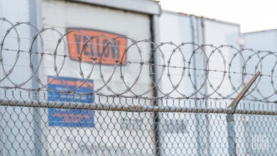 a closeup of Yellow trailers parked by a barbed wire fence in Houston