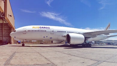 A white AlisCargo airline on the tarmac with a bright blue sky in the background. Side view.