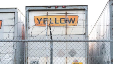 Yellow trailers backed up to a barbed-wire fence at a terminal in Houston