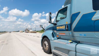 A side view of a blue Werner tractor on the highway