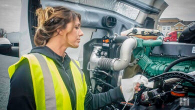 Truck driver checking engine