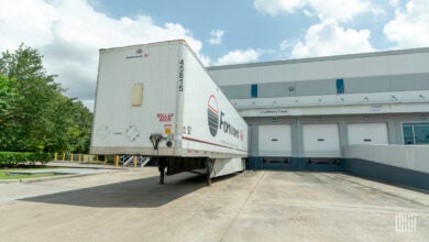 A white Forward Air trailer backed up to a Lufthansa terminal door