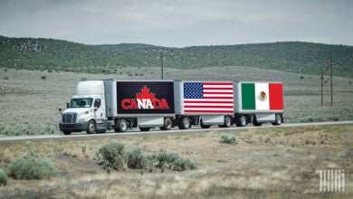 A tractor pulling three LTL trailers with Canada, U.S. and Mexico branding