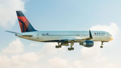 A blue-and-red tailed Delta jet heads into the open sky.