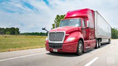 A maroon Knight tractor pulling a white Knight trailer on a highway