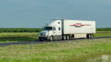 A white Pam tractor pulling a white Pam trailer