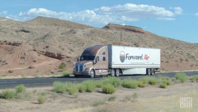 A sleeper cab pulling a white Forward Air dry van trailer