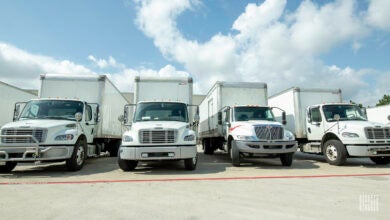 Several straight trucks loading at a facility