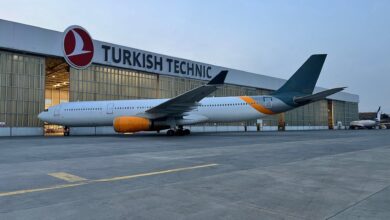 A passenger jet parked in front of a Turkish Technic hangar.