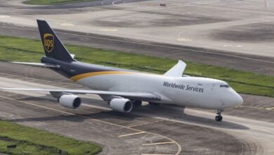 Overhead view of brown-tailed UPS jumbo jet moving along runway.