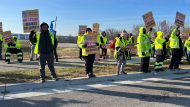 Workers in yellow vests picketing against DHL Express.