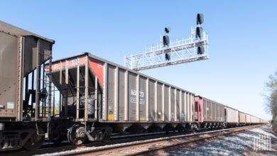 A train of railcars passes through a railroad crossing.