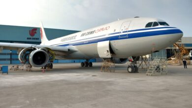 An Air China Cargo plane sitting on the tarmac next to a hangar.