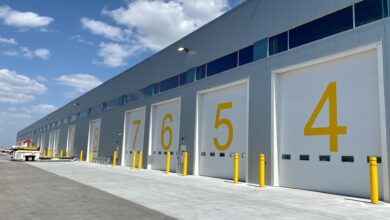 Dock doors at an airport painted with big yellow numbers, seen at an angle.