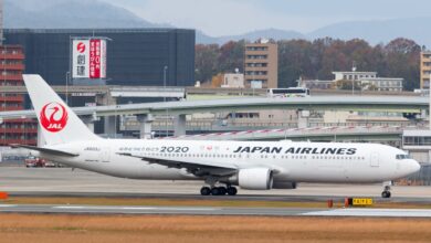 A Japan Airlines jet with red tail logo taxis to the runway.