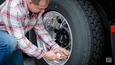 Truck driver checking tires.