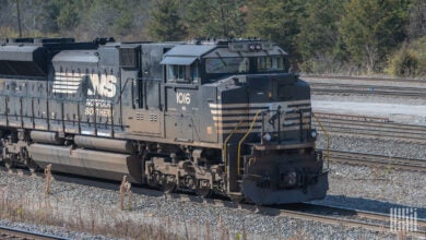 A locomotive with the initials N and S in the front is parked in a rail yard.