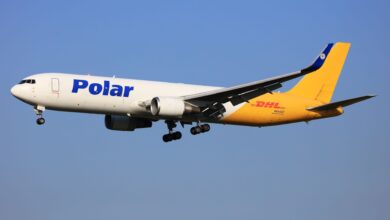 A half yellow, half white Polar cargo jet approaches runway with wheels down.