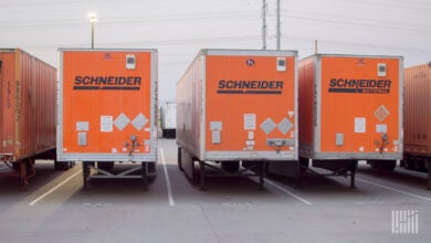 Multiple parked orange Schneider trucks