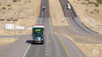 A green ABF tractor pulling a trailer on a New Mexico highway