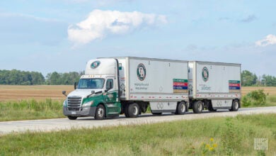 An Old Dominion tractor pulling two Old Dominion pup trailers on a highway