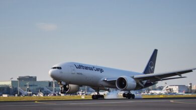 Blue-tailed Lufthansa Cargo jet touches down on a runway.