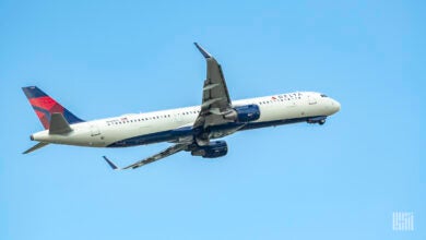 Blue-tailed Delta jet rises into a blue sky.