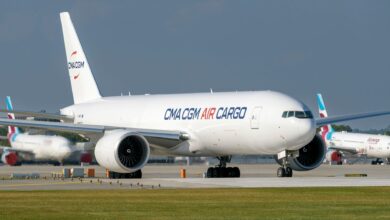 A white-hulled CMA CGM Air Cargo freighter taxis at an airport.