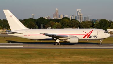 A white cargo jet with red ABX Air markings rolls down a taxiway.