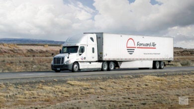 A white sleeper cab pulling a white Forward Air trailer on a highway