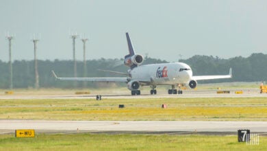 A FedEx jet at end of the runway begins its takeoff.