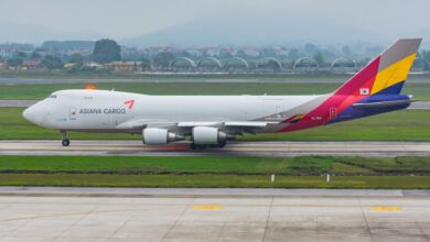 An Asiana Cargo Boeing 747-400 jumbo jet rolls on runway.