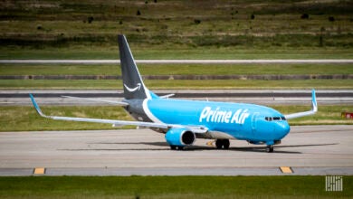 A dark-and-light blue Amazon Prime Air cargo jet on the runway.