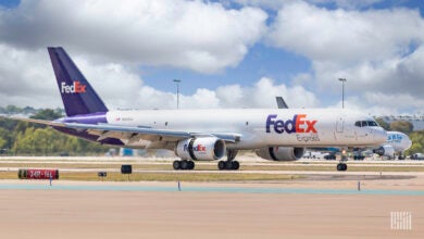 A purple-tail FedEx Express jet on the ground at an airport.