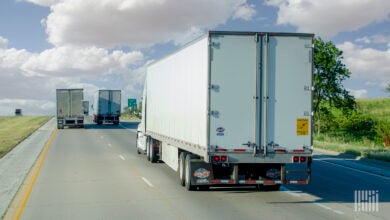 a rearview of multiple tractor-trailers on a highway