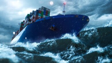 Close up image from in front of the bow of a container ship lurching in high seas.