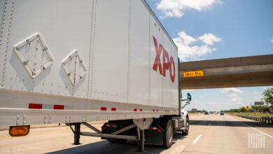 An XPO trailer being pulled on a highway