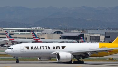 A gold tailed Kalitta Air freighter on the ground at an airport.