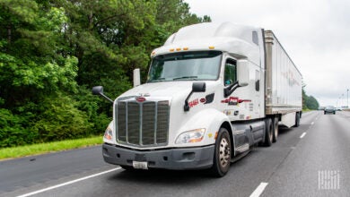 A white Pam Transportation tractor pulling a dryvan trailer on a highway