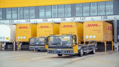 Yellow DHL trucks at a loading dock.