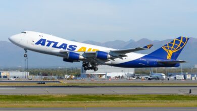 A blue-and-gold tail Atlas Air jumbo jet takes off from airport.