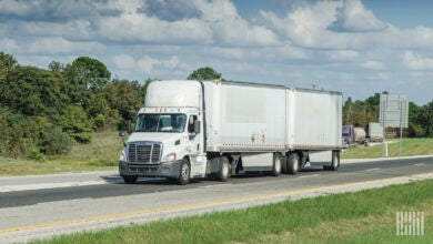 a white tractor pulling two LTL pup trailers