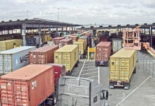 Images shows container trucks, port gates, cloudy sky