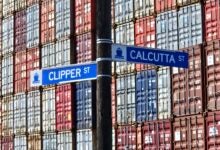 Image shows street signs and stack of containers.