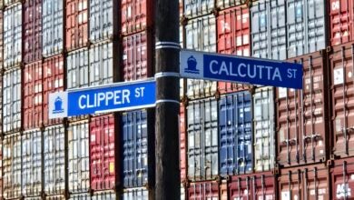 Image shows street signs and stack of containers.