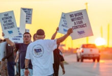 Images shows striking union members holding signs.