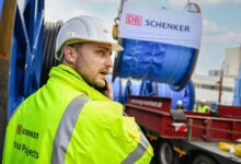 Image shows a Schenker worker and trailer with cargo.