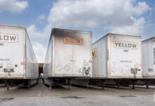 Faded Yellow trailers with exhaust stains parked at a terminal