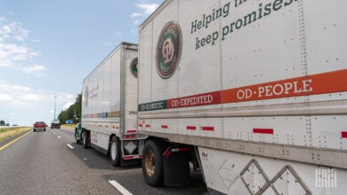 A sideview of two Old Dominion pup trailers being pulled on a highway