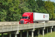 A red Knight sleeper cab pulling a Knight dryvan trailer